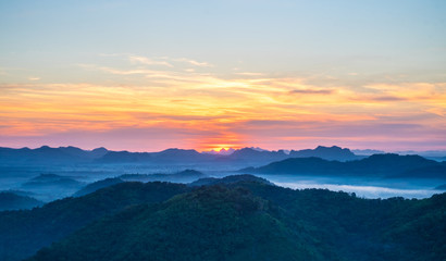 Beautiful sun was rising over the mountains with sky and cloud view from top mountain at Phu Bo Bit, Loei, Thailand