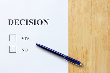 Decision paper with yes and no choice on wood background