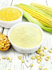 Flour and grits corn in bowls with cobs on board