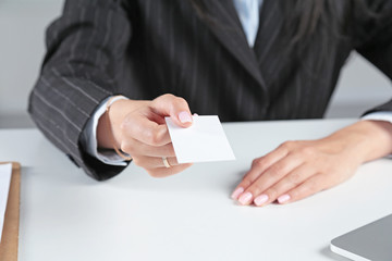 Businesswoman holding blank visit card ,sitting on the desk