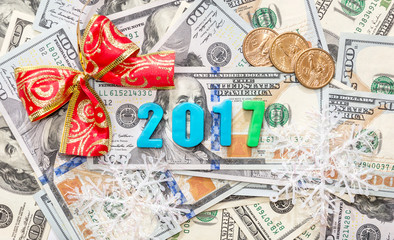 2017 text from plastic numbers with bow and coins on dollars bac