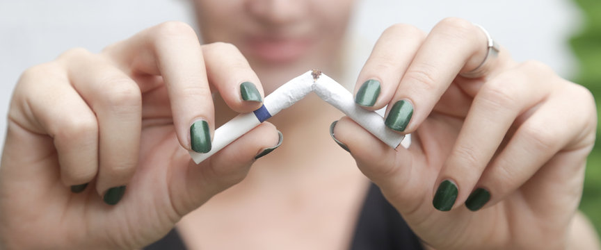 Young Woman Breaking Down Cigarette To Pieces. - Quit Smoking Concept