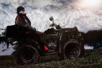 Fototapeta premium Mann sitzt auf ATV / Quad und wartet