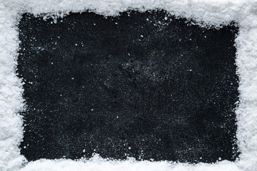 Sea salt grains frame on the black background.