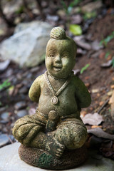 stone figurine on the ground among the leaves