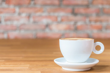A cup of hot coffee on wood table with blur background