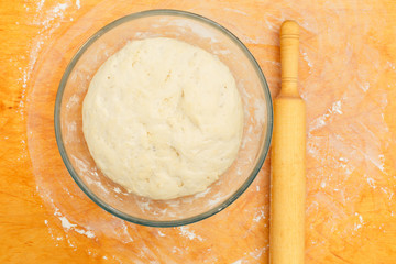 Cup with dough , rolling pin