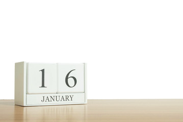 Closeup surface white wooden calendar with black 16 january word on blurred brown wood desk isolated on white background with copy space , selective focus at the calendar