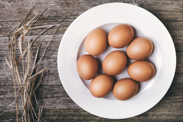 chicken eggs on old wooden table, rustic rural background