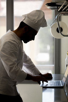 Chef Using Laptop On Worktop