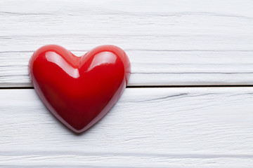 Red heart on white wooden planks