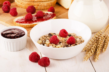 Healthy dietary breakfast with muesli, milk, fresh raspberries a
