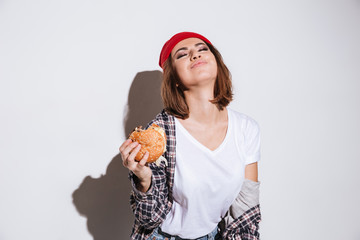 Hungry young woman eating burger