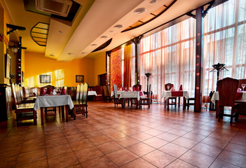 a large banquet hall, where through the glass window the sun is