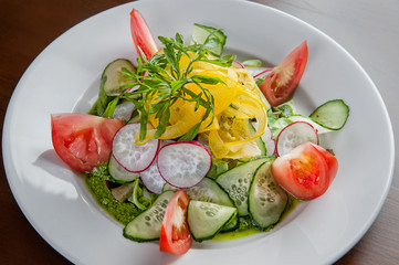 Salad with fresh vegetables. Sliced tomatoes, cucumber, radishes