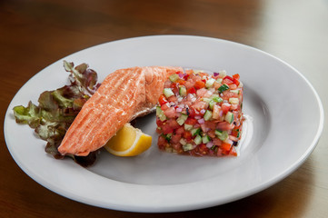 Blanched salmon lying on a lemon drop. Near tartare decorated in