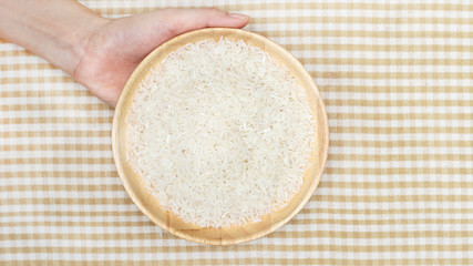 White rice on wooden plate hold by hands 2
