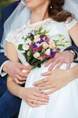 Obraz na płótnie Canvas Bride and groom on their wedding day outdoors. wedding bouquet in bride's hand