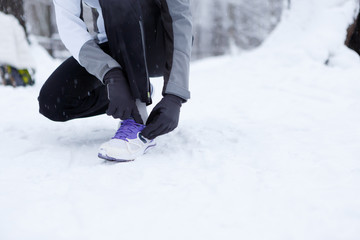 Fototapeta na wymiar Girl corrects shoes in winter