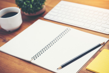 Coffee cup and keyboard computer notebook on wooden table background