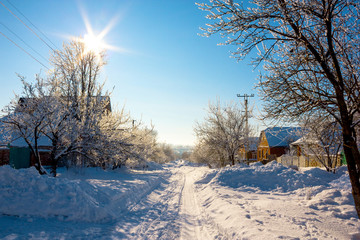descent through the village through the white snow, surrounded by trees with sunlight