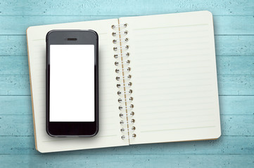 Blank screen  phone on book in wooden background.Photo with copy space.