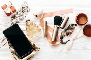 Fototapeta na wymiar smart phone with empty screen and luxury jewelry perfume present