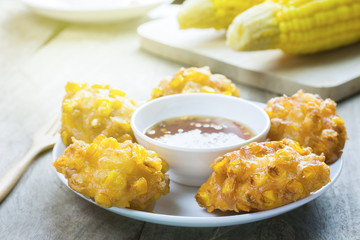 Crispy fried corn ball in a white plate on wooden table,Vegetari