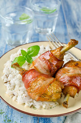 Bacon wrapped chicken legs with rice garnish