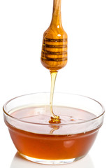 Honey dripping from a wooden dipper