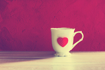 White mug with a heart on a red background