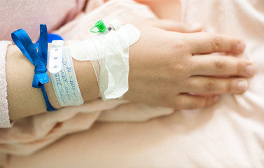 Obraz na płótnie Canvas Newborn baby in hospital with id ribbon on his hand