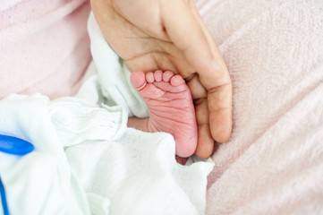 Newborn baby in hospital with id ribbon on his hand