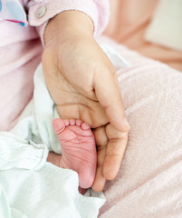 Newborn baby in hospital with id ribbon on his hand