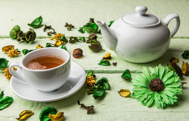White teapot and cup with tea