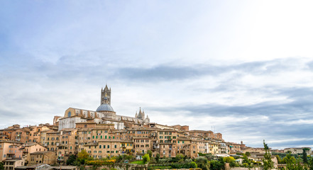 Fototapeta na wymiar Panoramic view of the historic city of Siena with the cathedral on a cloudy day in Tuscany, Italy.