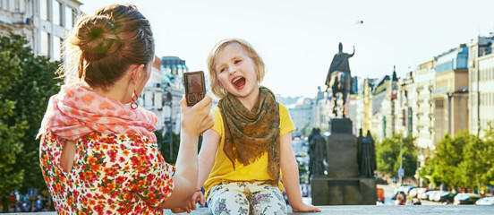 mother and daughter tourists with camera taking photo, Prague