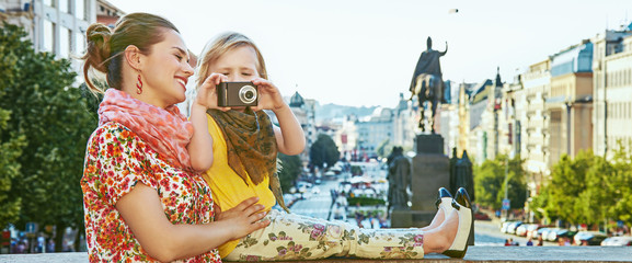 mother and daughter tourists with camera taking photo in Prague