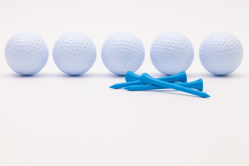 White golf balls and wooden tees on the white background.