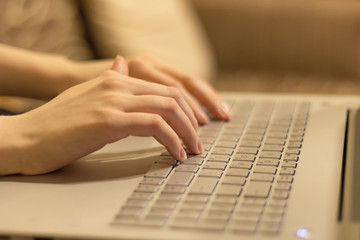 Woman working at home office, hands on laptop keyboard . close up