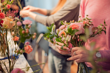 Workshop florist, making bouquets and flower arrangements. Woman collecting a bouquet of roses....