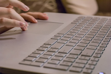 Woman working at home office hand on keyboard close up