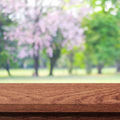 Empty wooden table over blurred tree with bokeh background