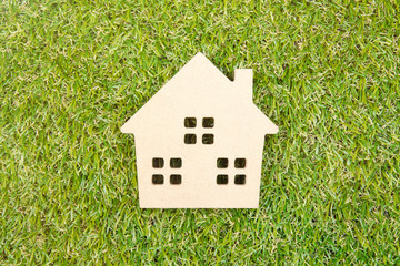 Wooden house toy on ground green grass with copy space.Real esta