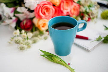 Cup of tea on the table, relax. Workshop florist, table with flowers, still life. Soft focus