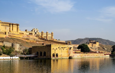 Obraz premium View of part of the ancient Amber fort, walls, gates and adjoining building with bridge from the Maota Lake. Jaipur, India.