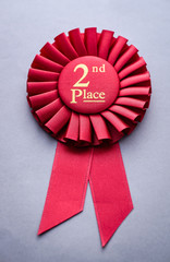 Second place red winners rosette on grey