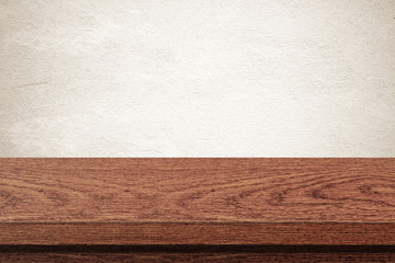 Empty wooden table over grunge cement wall background