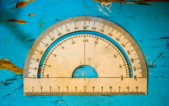 Overhead view of vintage protractor on blue table