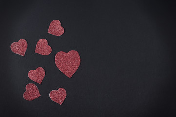 Glittered red Valentine's hearts card on black background
